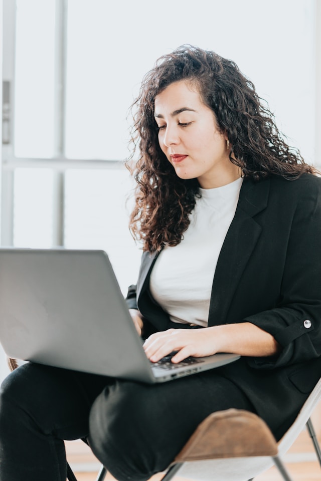 a headshot of a woman working on her laptop