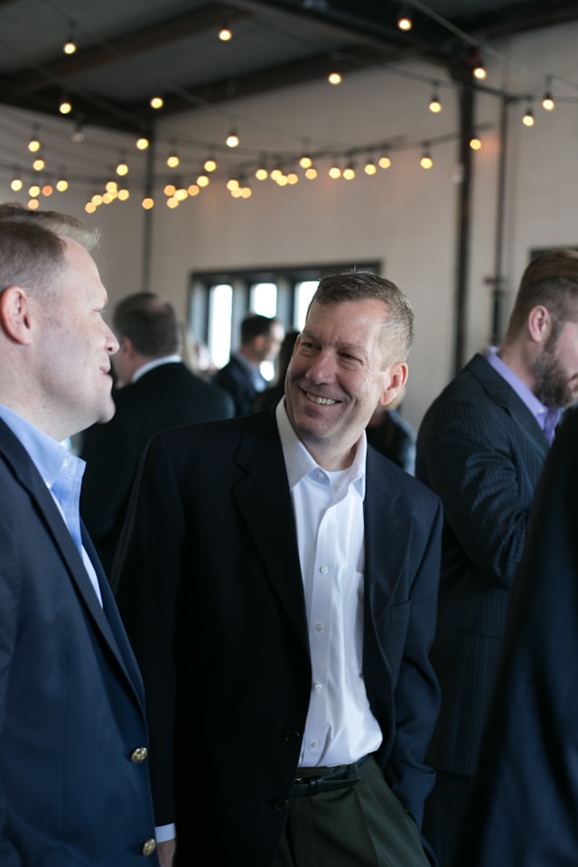 two men chat and smile at a 20 groups meet up