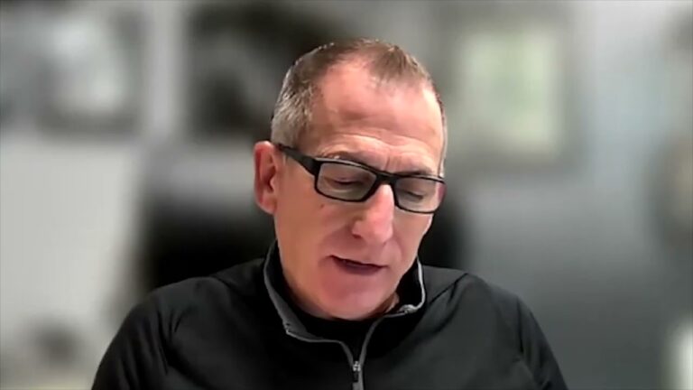 Jerry Brouwer, wearing a black jacket and glasses, sits facing the camera on a zoom training for marine dealers