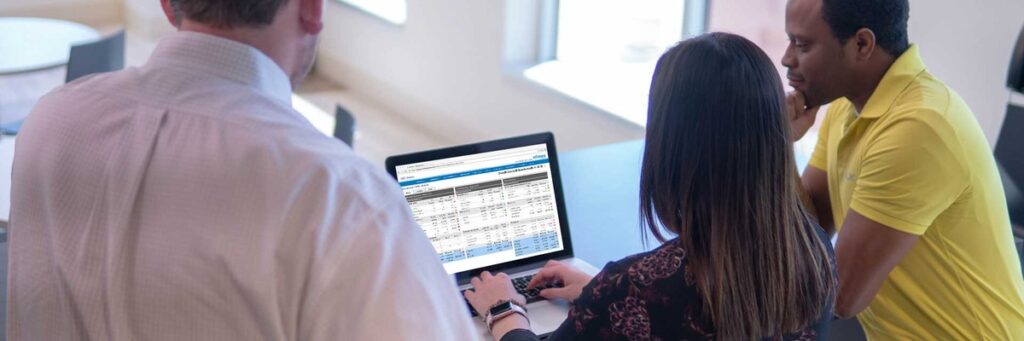 a group of three people are gathered around a laptop with an axcessa dashboard displayed