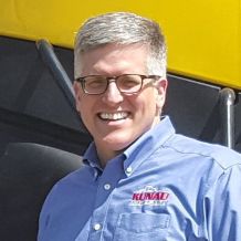 A close up photo of Todd Kunau smiling and wearing a Kunau company shirt.