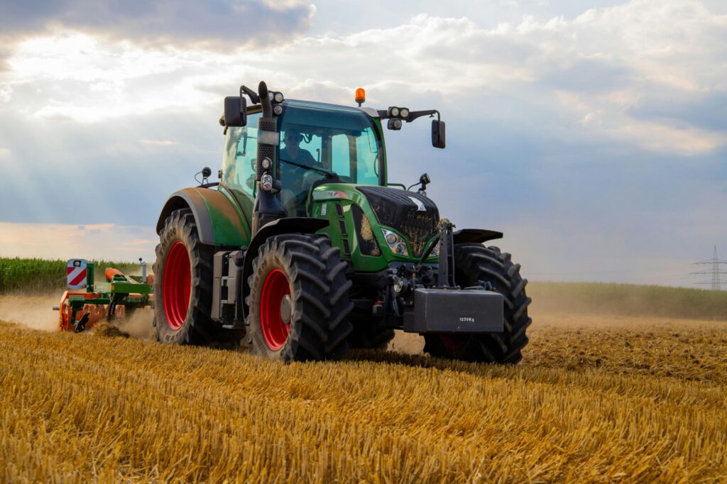 A large tractor is plowing a field.