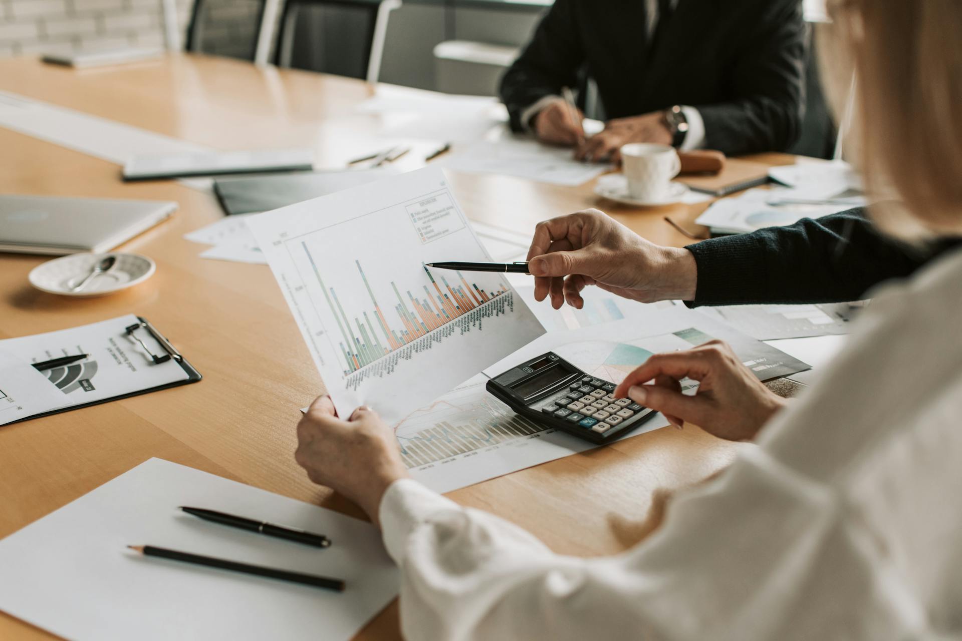 a close up view of people discussing some graphs in an office setting.